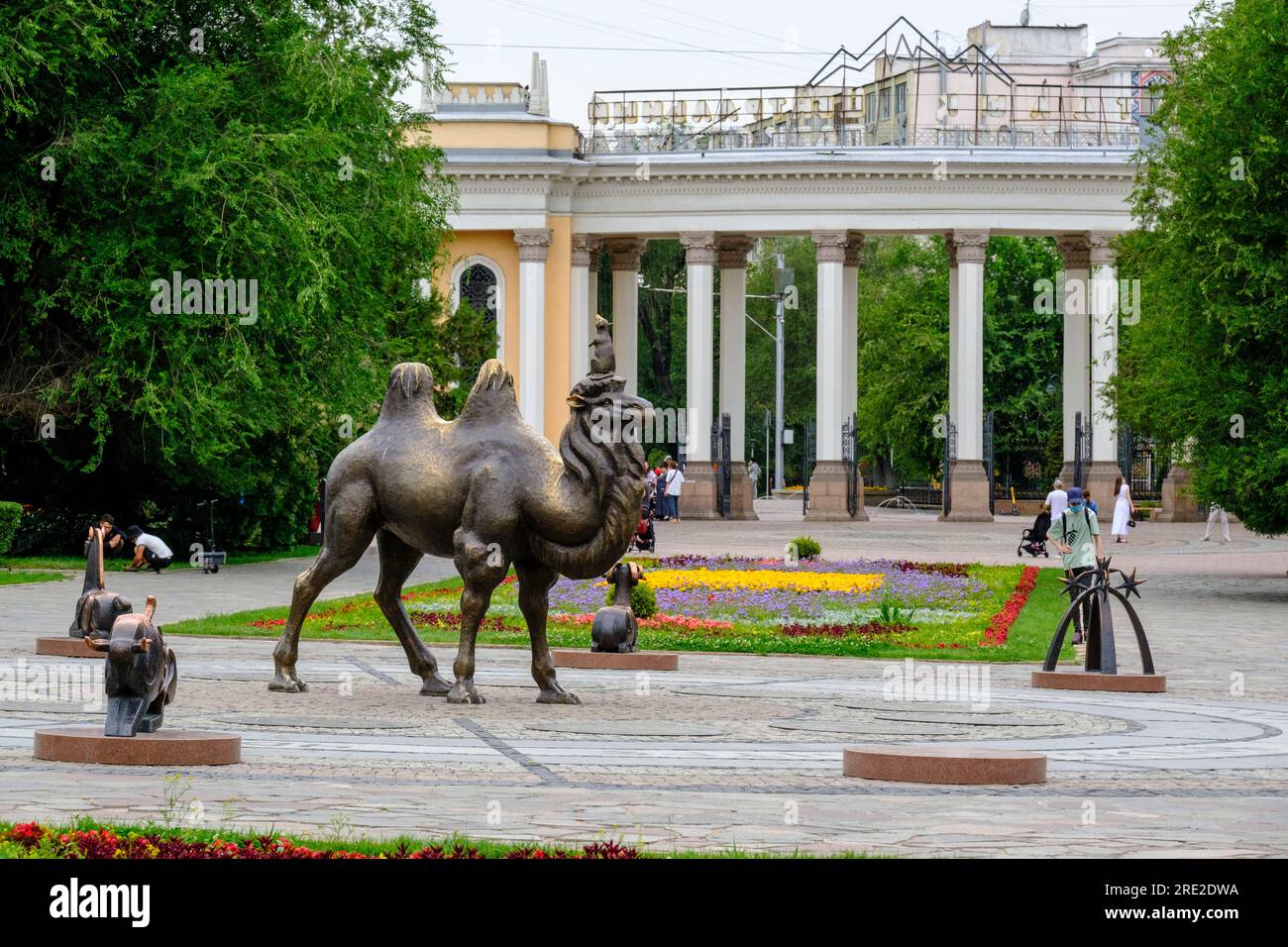 Kazakistan, Almaty. Statua di cammello della Bactrian, ingresso al Central Park for Culture and Recreation sullo sfondo. Foto Stock