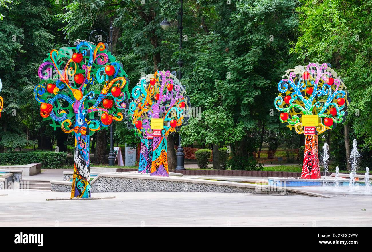 Kazakistan, Almaty. Alberi decorativi colorati vicino alla fontana, Central Park for Culture and Recreation. Foto Stock