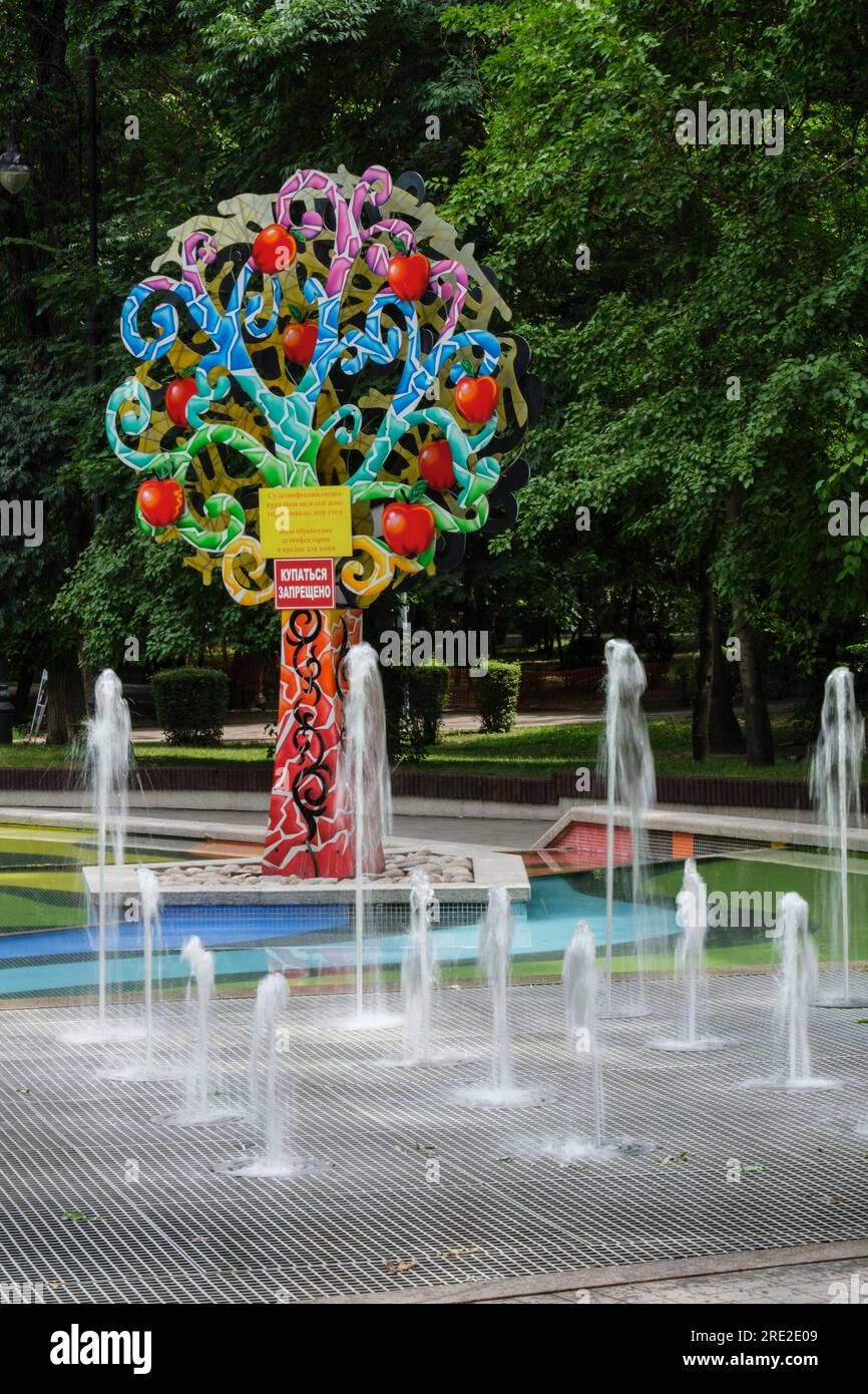 Kazakistan, Almaty. Alberi decorativi colorati vicino alla fontana, Central Park for Culture and Recreation. Foto Stock