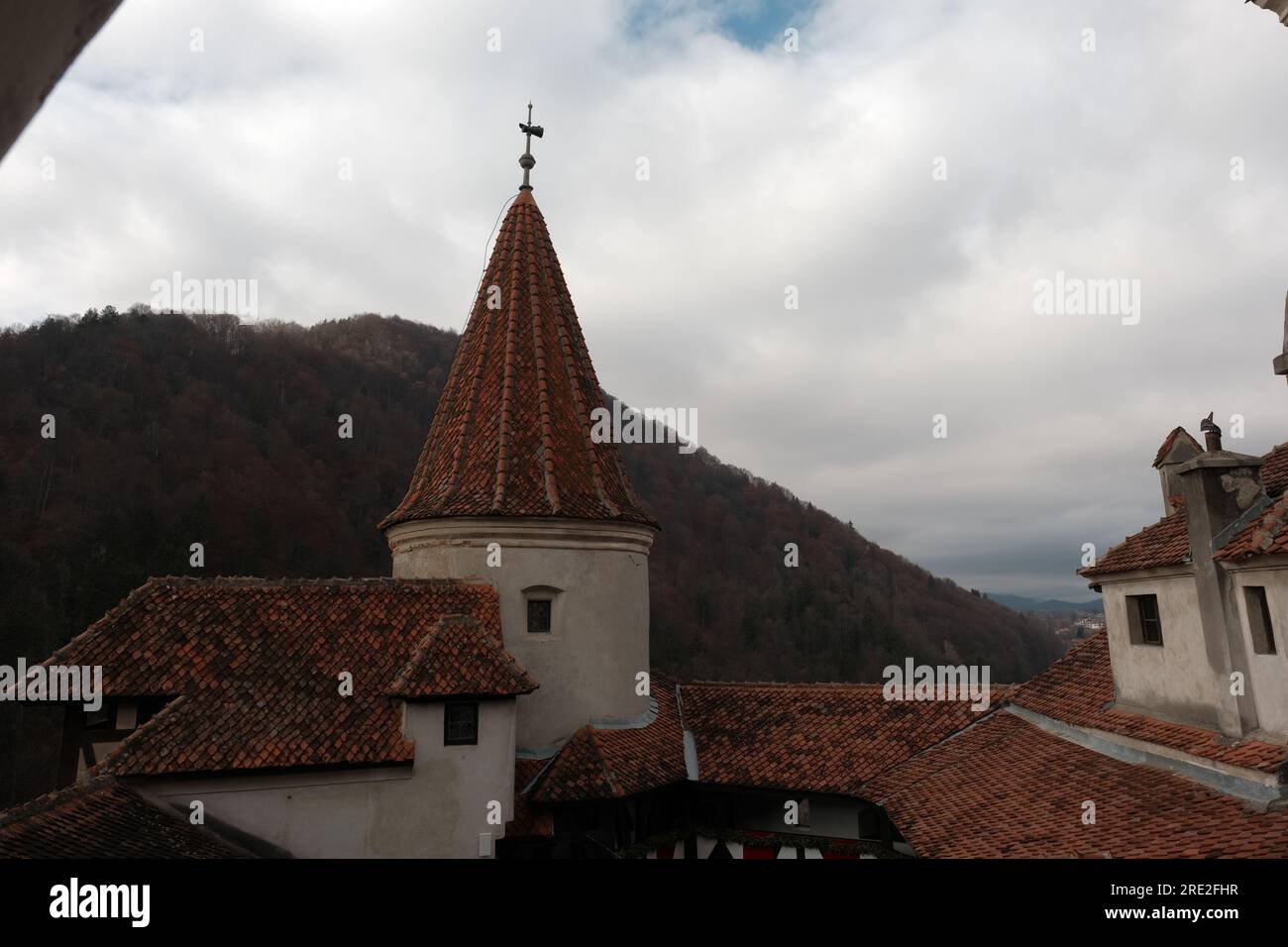 Una vista spettacolare di una delle torri del Castello di Bran che si ergono alte contro un cielo nuvoloso rumeno, infondendo la scena con un senso di mistero e di storia Foto Stock