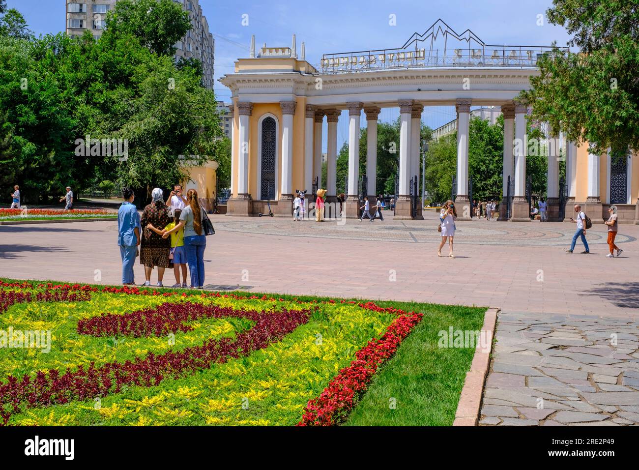 Kazakistan, Almaty. Le famiglie in posa per una foto all'ingresso di Central Park per la cultura e il tempo libero. Foto Stock