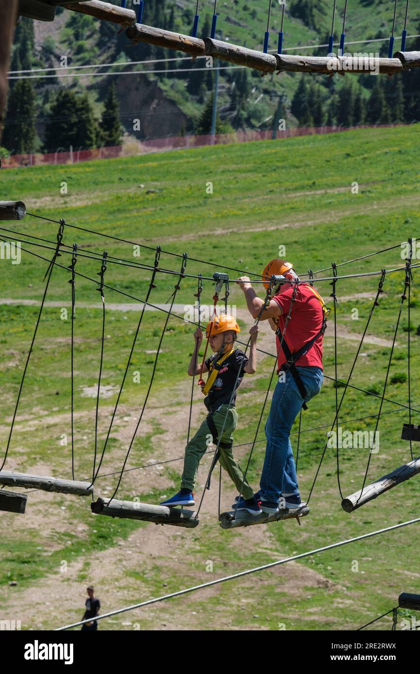 Kazakistan, stazione sciistica di Shymbulak. Padre e figlio su un apparato per costruire la fiducia. Foto Stock