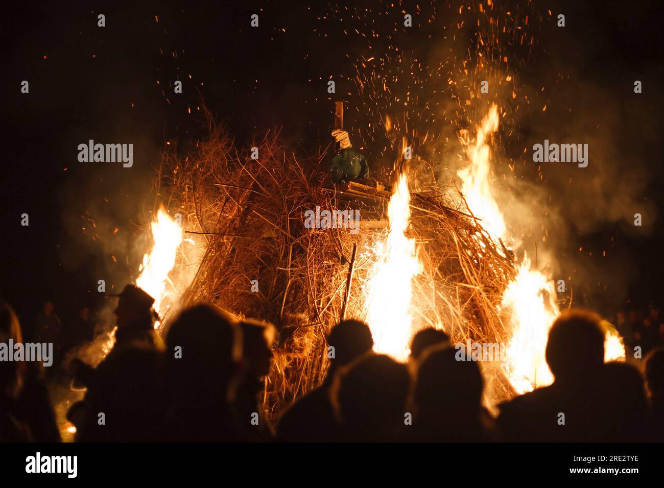 La gente guarda come un'effigie di Guy Fawkes brucia nella notte del falò a Surrey, Inghilterra, Regno Unito. Nessun volto riconoscibile Foto Stock