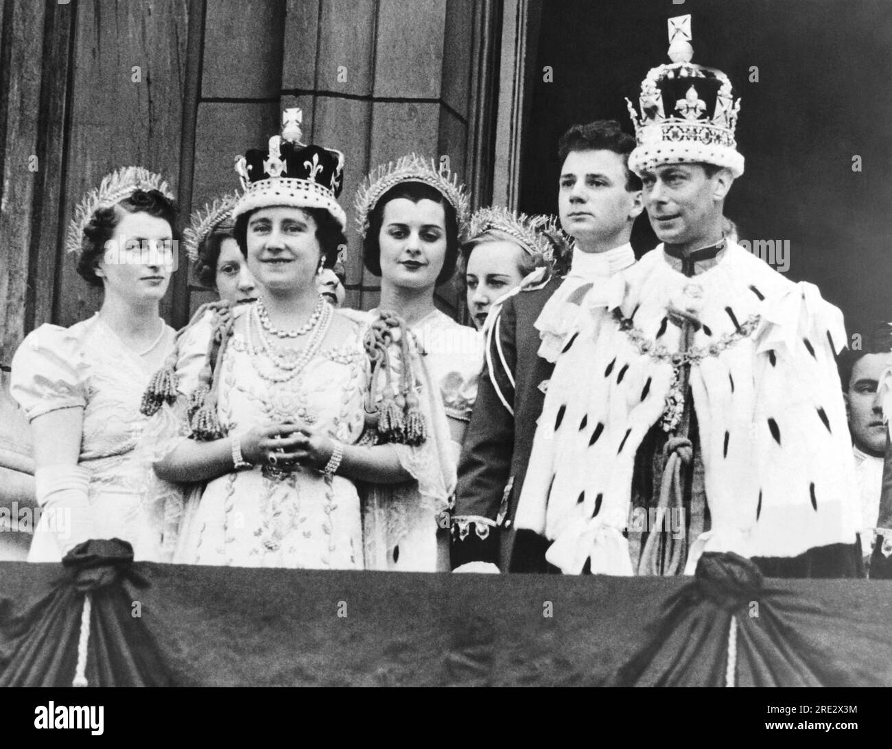 Londra, Inghilterra: 12 maggio 1937 Re Giorgio vi e la Regina Elisabetta nel giorno dell'incoronazione sul balcone di Buckingham Palace. A destra della Regina c'è Lady Ursula Manners, una delle sue sei portatori di addestramento, e a sinistra del Re c'è Earl Kitchener, una delle nove pagine che portavano il treno del Re all'incoronazione. Foto Stock