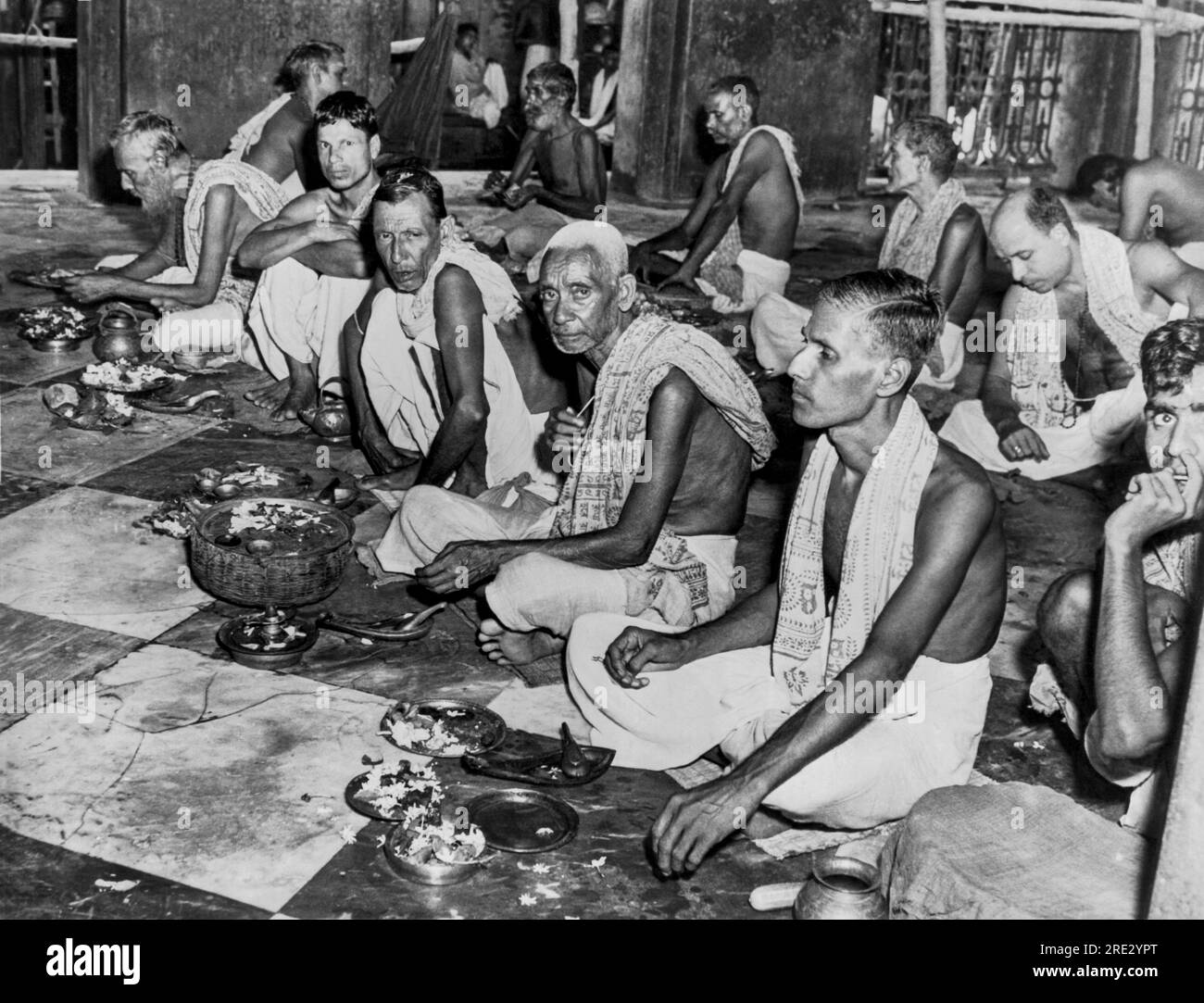 Kalighat, India: circa 1948 culto bramino nel tempio di Kalighat. I bramini sono la casta più alta degli indù, con il loro segno distintivo che è il pezzo di corda visto nella mano del bramino anziano dai capelli grigi. Foto Stock