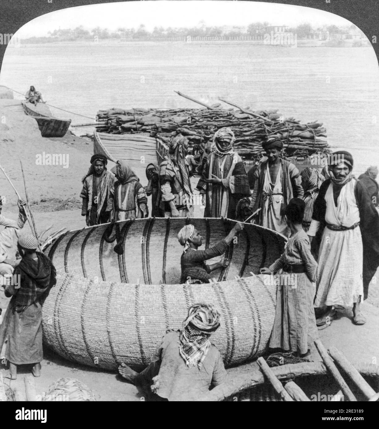 Baghdad, Iraq: circa 1900 operai che costruiscono una barca rotonda araba nota come kufa sul fiume Tigri a Baghdad. Foto Stock