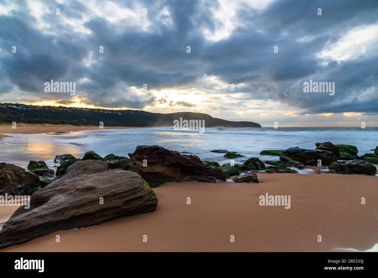 Alba al mare con nuvole, rocce e onde a Killcare Beach sulla Central Coast, New South Wales, Australia. Foto Stock