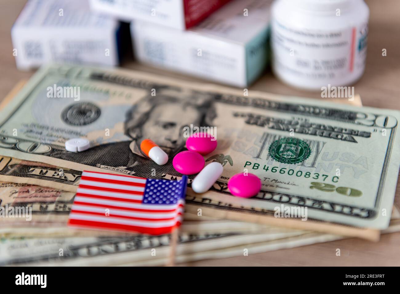 Un costo medico, un grande concetto farmaceutico con un bicchiere d'acqua, varie medicine, banconote in dollari americani e la bandiera americana. Foto Stock