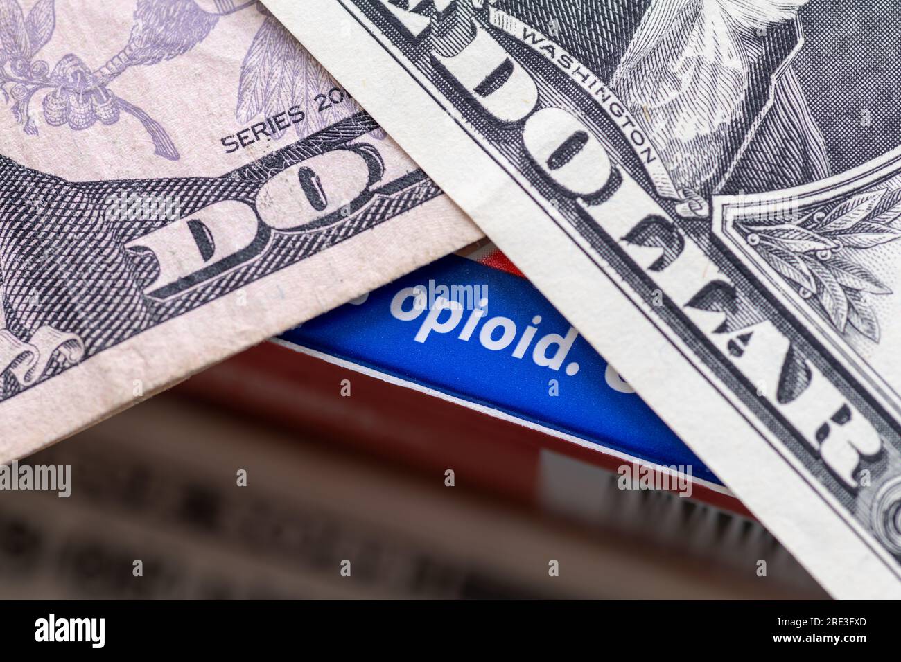 Un concetto di dipendenza da oppioidi con una scatola di farmaci contenente oppioidi e banconote da dollari in cima. Foto Stock