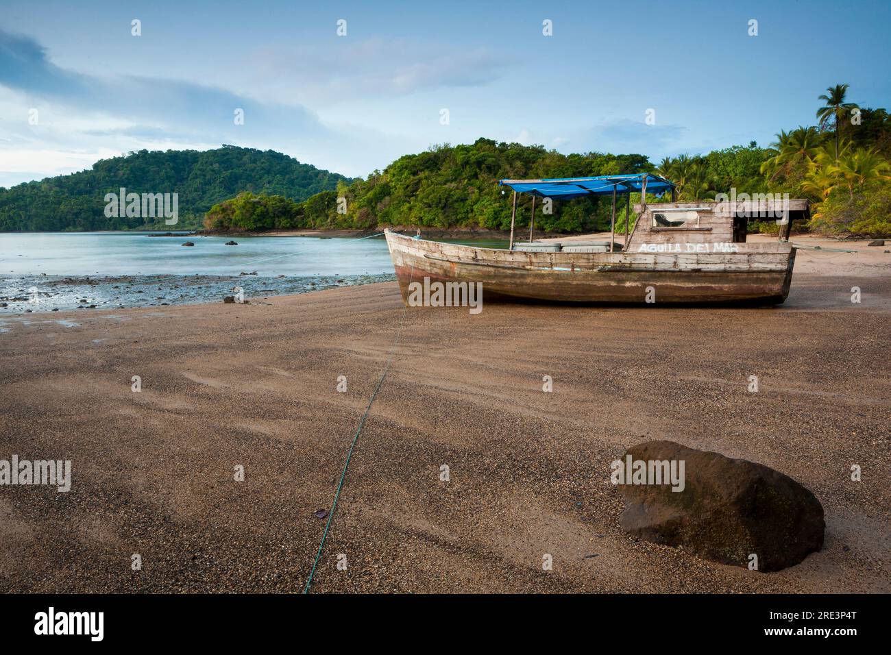 Barca da pesca sulla spiaggia con bassa marea a Coiba Island, costa del Pacifico, provincia di Veraguas, Repubblica di Panama, America centrale. Foto Stock