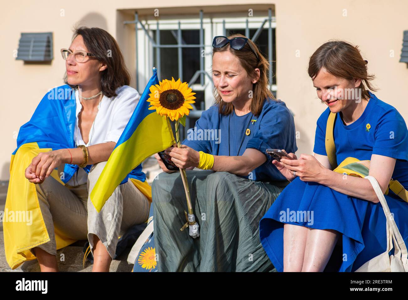 Tre donne ucraine con bandiere e girasole durante una manifestazione pacifica contro la guerra, Putin e la Russia a sostegno dell'Ucraina Foto Stock
