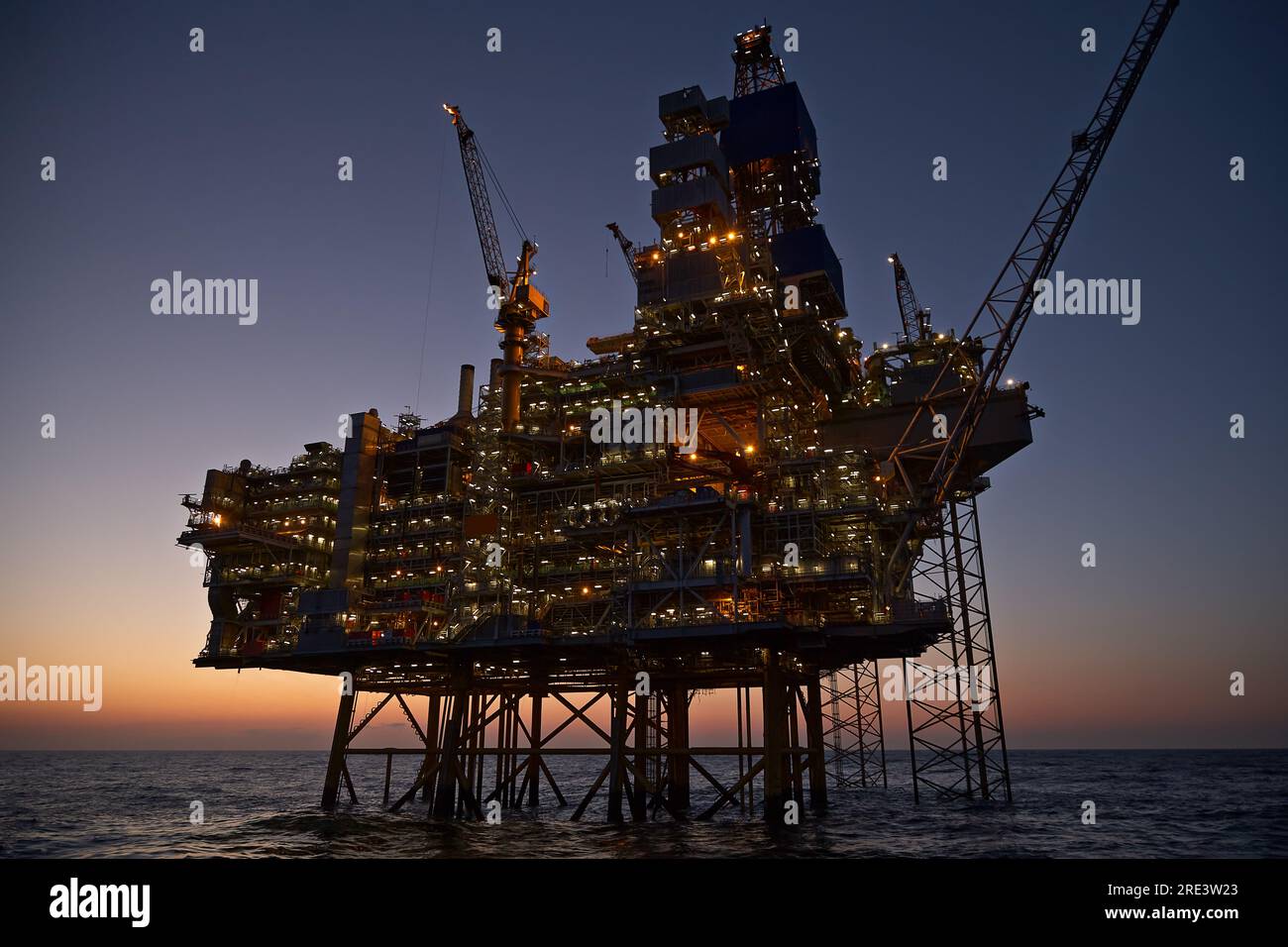 Piattaforma offshore per il petrolio e il gas nel mare al tramonto. Foto Stock