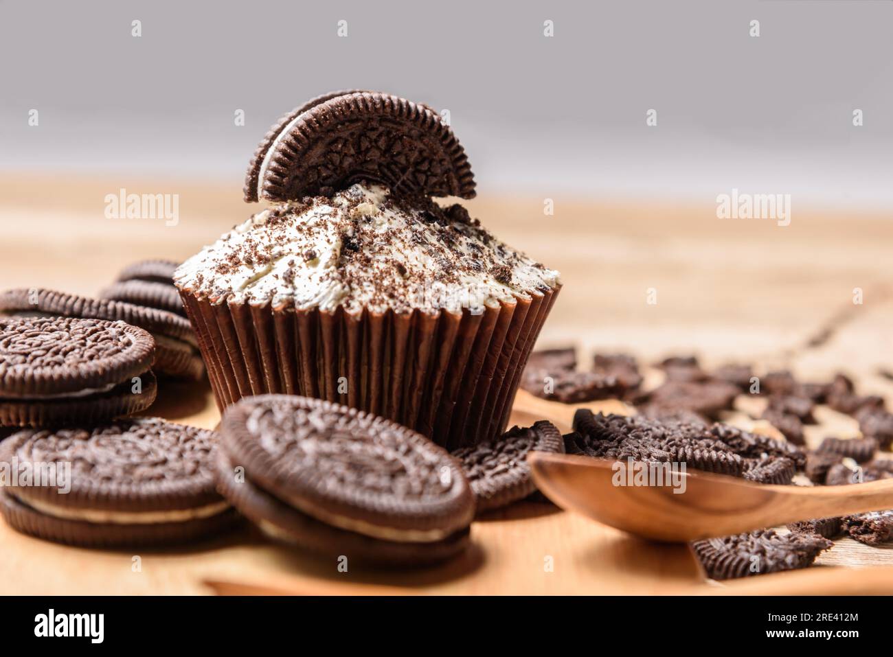 Cupcake al cioccolato bianco con biscotti sopra Foto Stock