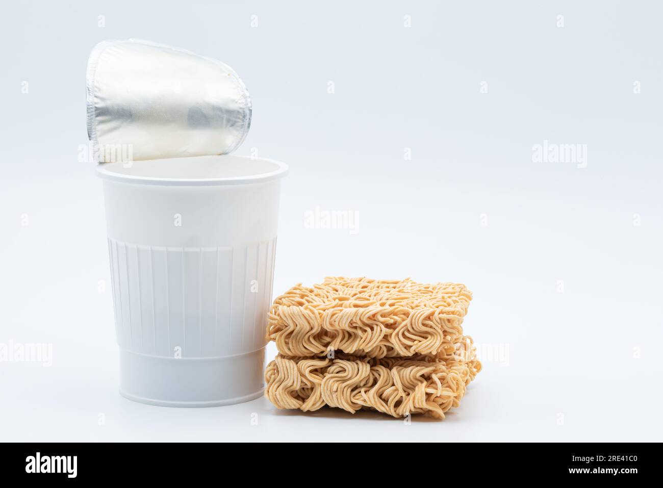Spaghetti istantanei con tazza in plastica su sfondo bianco Foto Stock