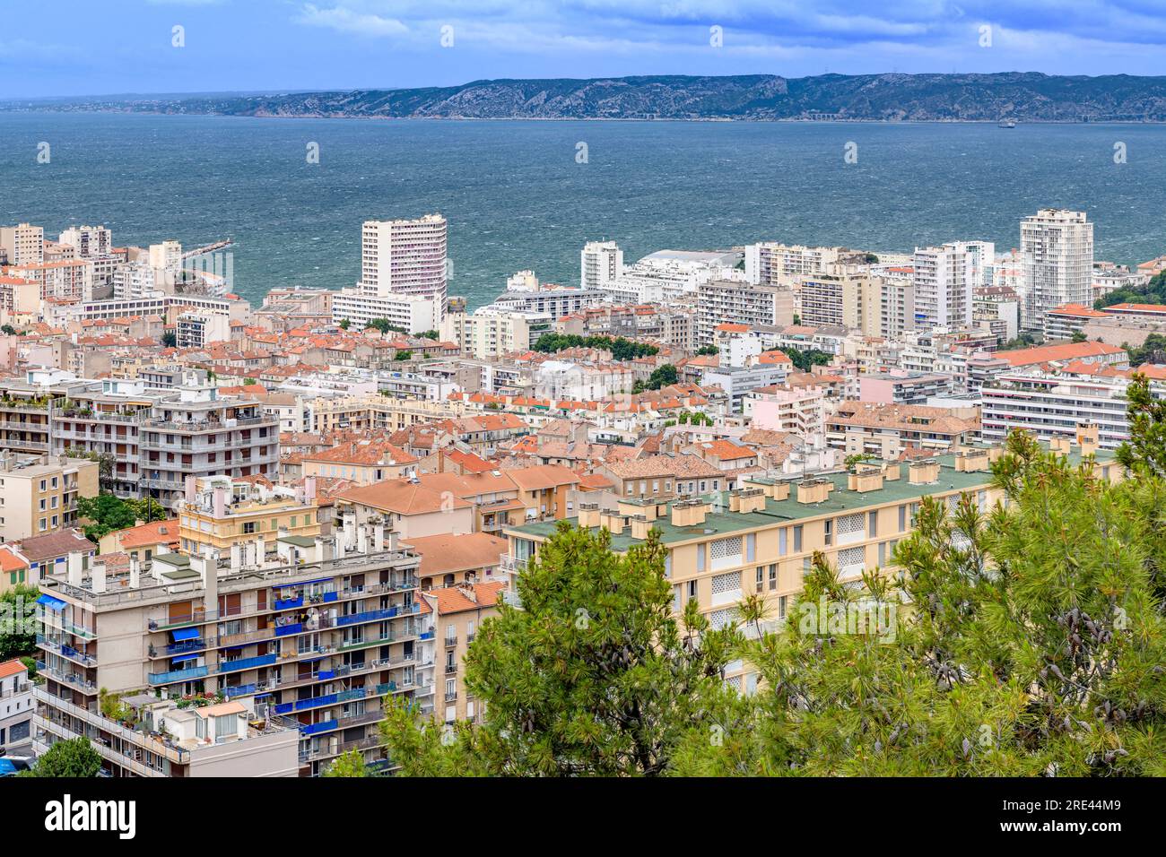 Vista sulla città di Marsiglia, scattata dalla Basilica di Notre-Dame de la Garde, con vista sui tetti in terracotta, sulle strade tortuose e sulle montagne lontane. Foto Stock