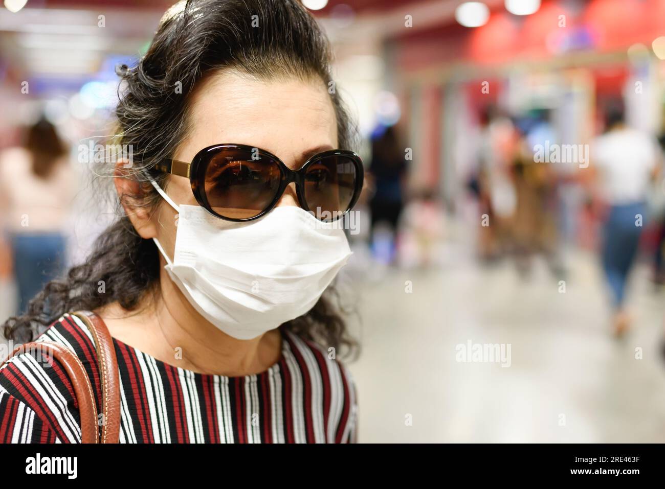 Le donne che indossano maschere per prevenire l'infezione da coronavirus camminano in metropolitana con persone affollate. Foto Stock