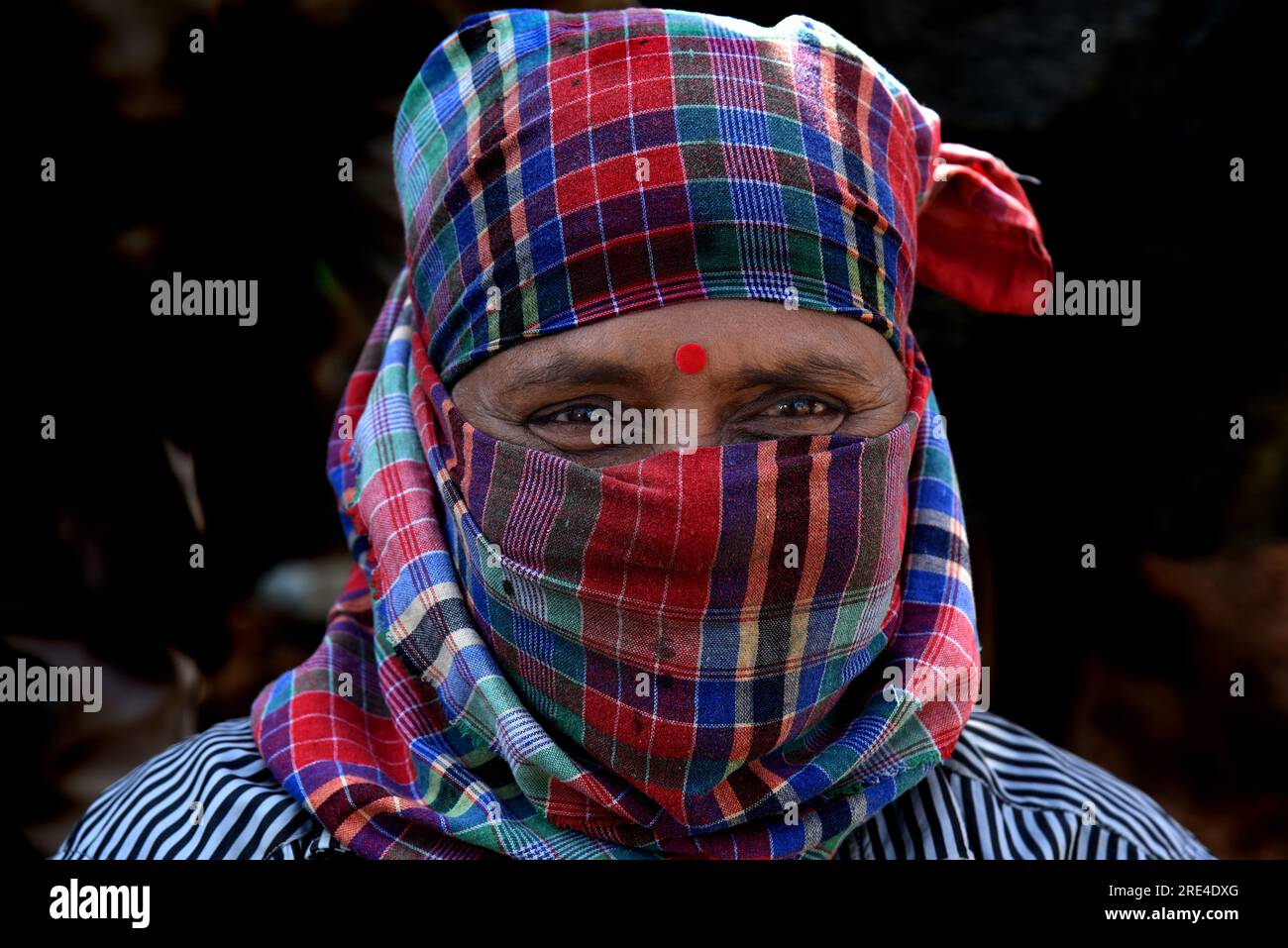 Ritratto di un uomo indiano che lavora in un cantiere in condizioni di lavoro difficili sia per uomini che per donne. India. Foto Stock