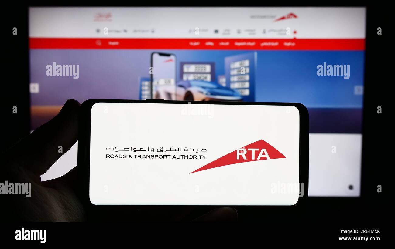 Persona che possiede uno smartphone con il logo della Emirati Roads and Transport Authority (RTA) sullo schermo di fronte al sito Web. Concentrarsi sul display del telefono. Foto Stock