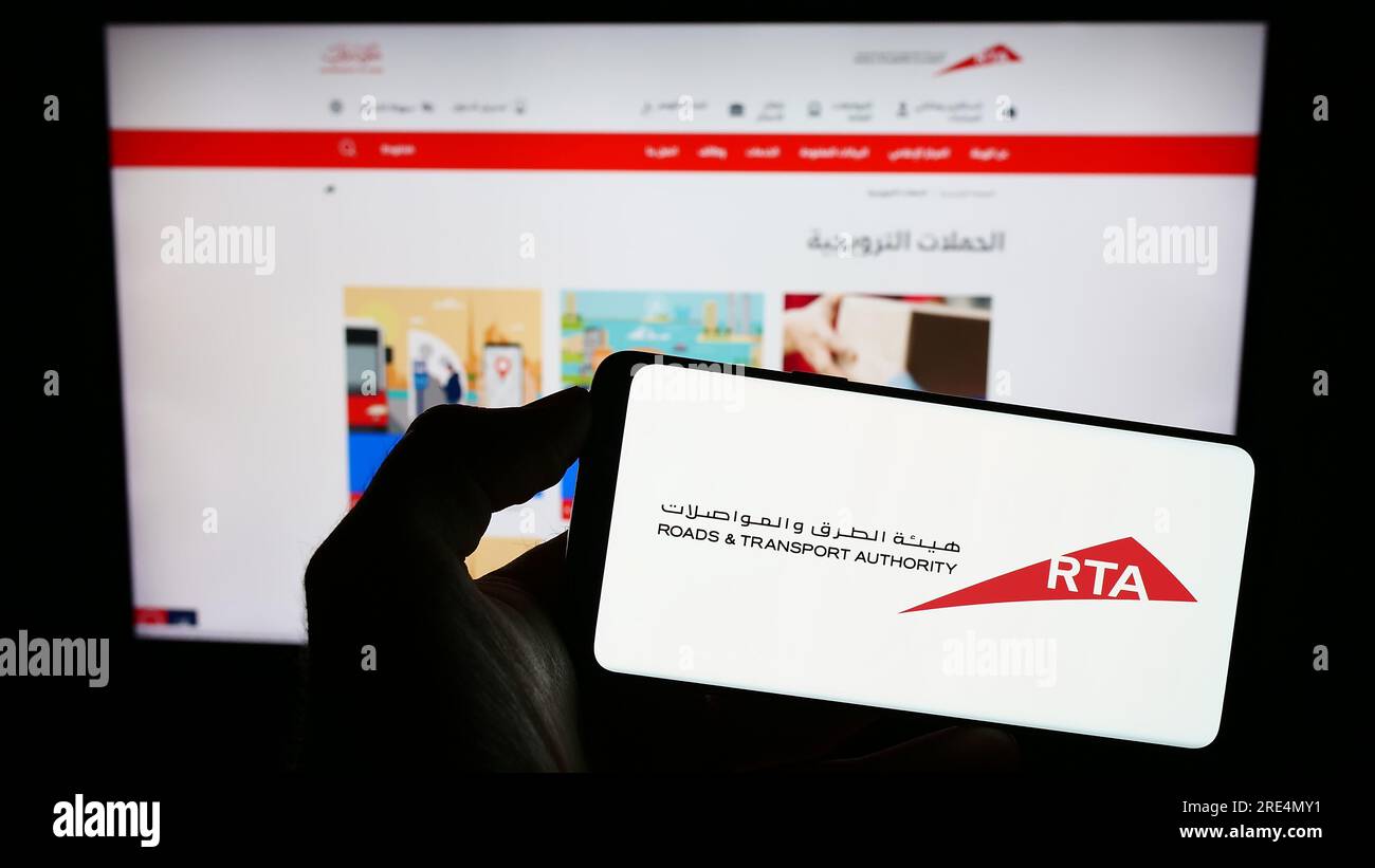 Persona in possesso di un cellulare con il logo della Emirati Roads and Transport Authority (RTA) sullo schermo davanti alla pagina Web. Concentrarsi sul display del telefono. Foto Stock