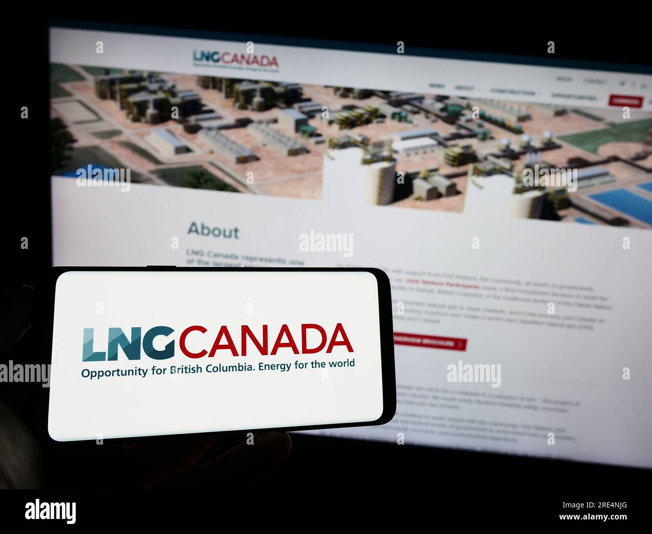 Persona che tiene il cellulare con il logo del progetto di energia industriale LNG Canada sullo schermo davanti alla pagina web. Concentrarsi sul display del telefono. Foto Stock