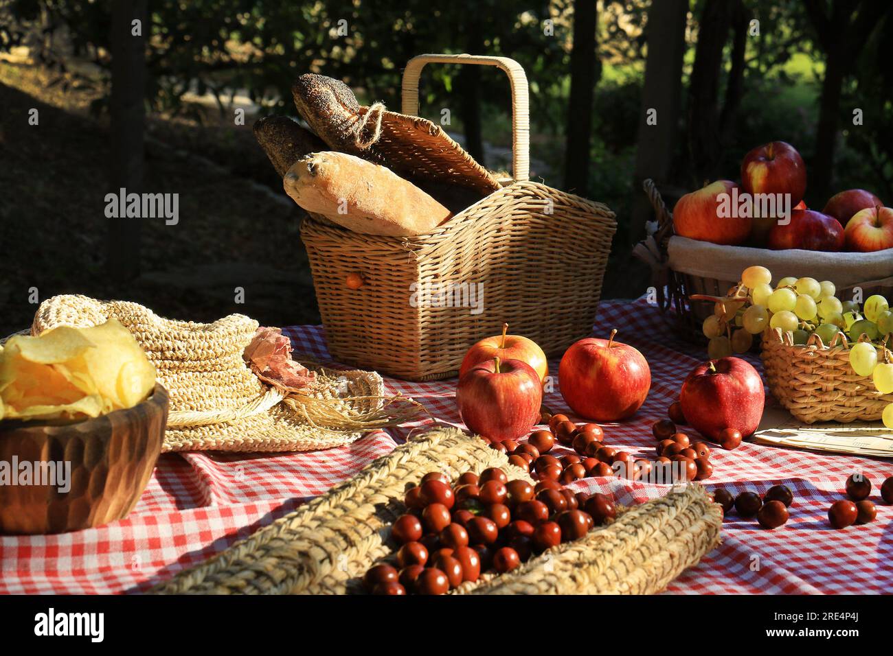 Un picnic al sole con pane, mele, giuggiole e meringa. Foto Stock