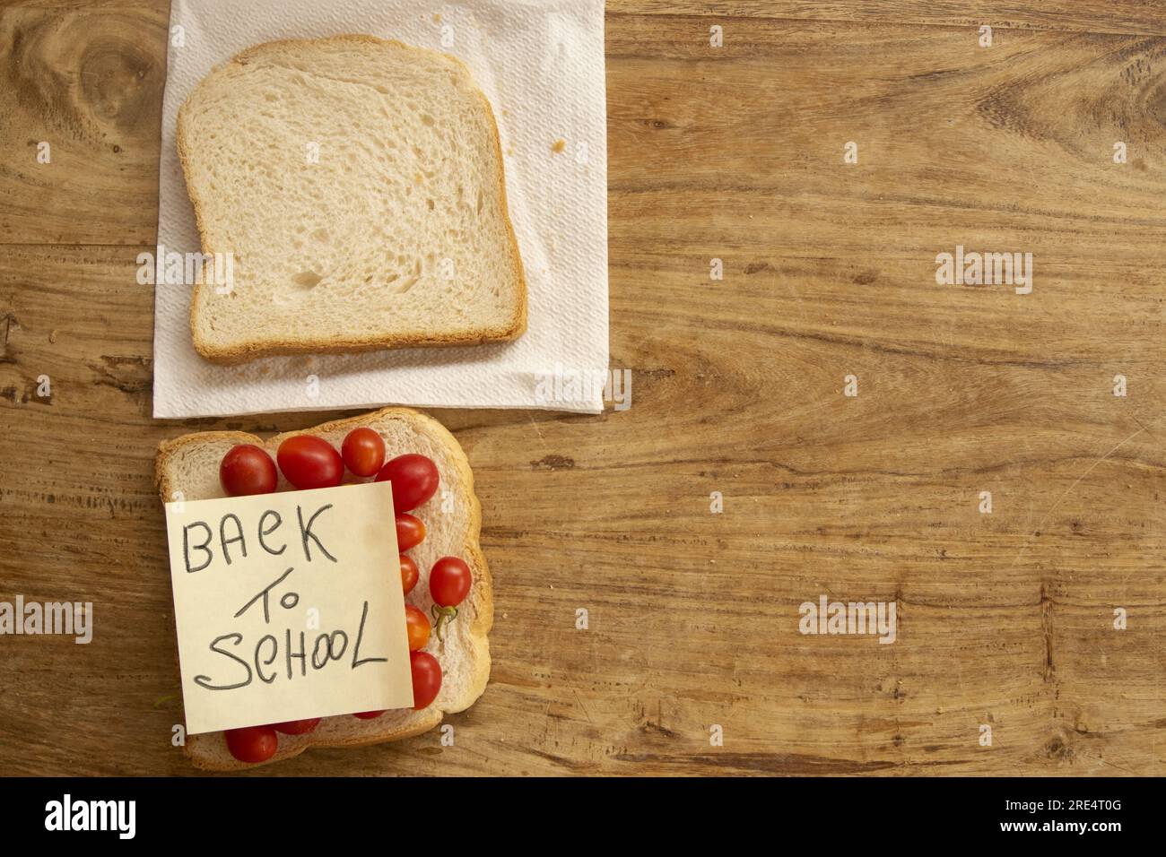 concetto di ritorno a scuola con un panino e scrivere su un post Foto Stock