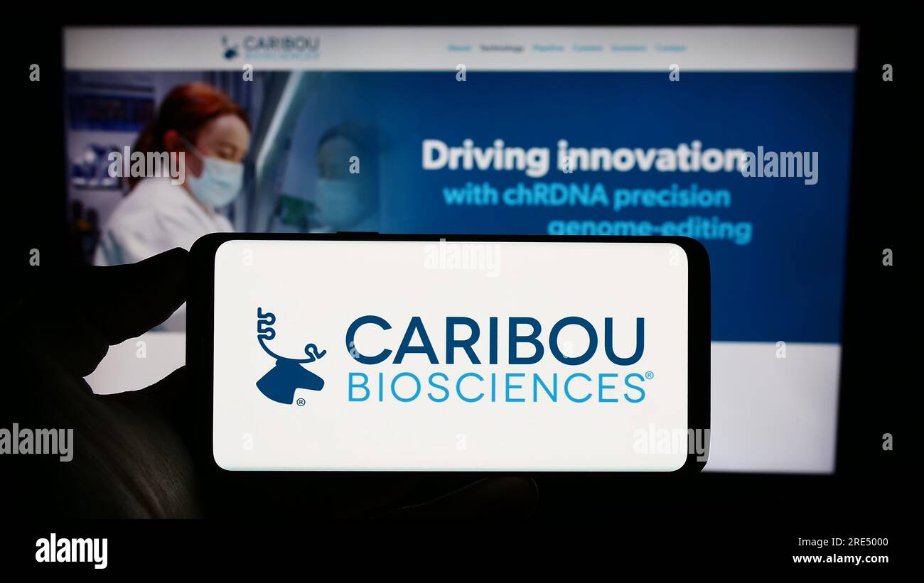 Persona che possiede il cellulare con il logo della società statunitense Caribou Biosciences Inc. Sullo schermo davanti alla pagina Web aziendale. Concentrarsi sul display del telefono. Foto Stock