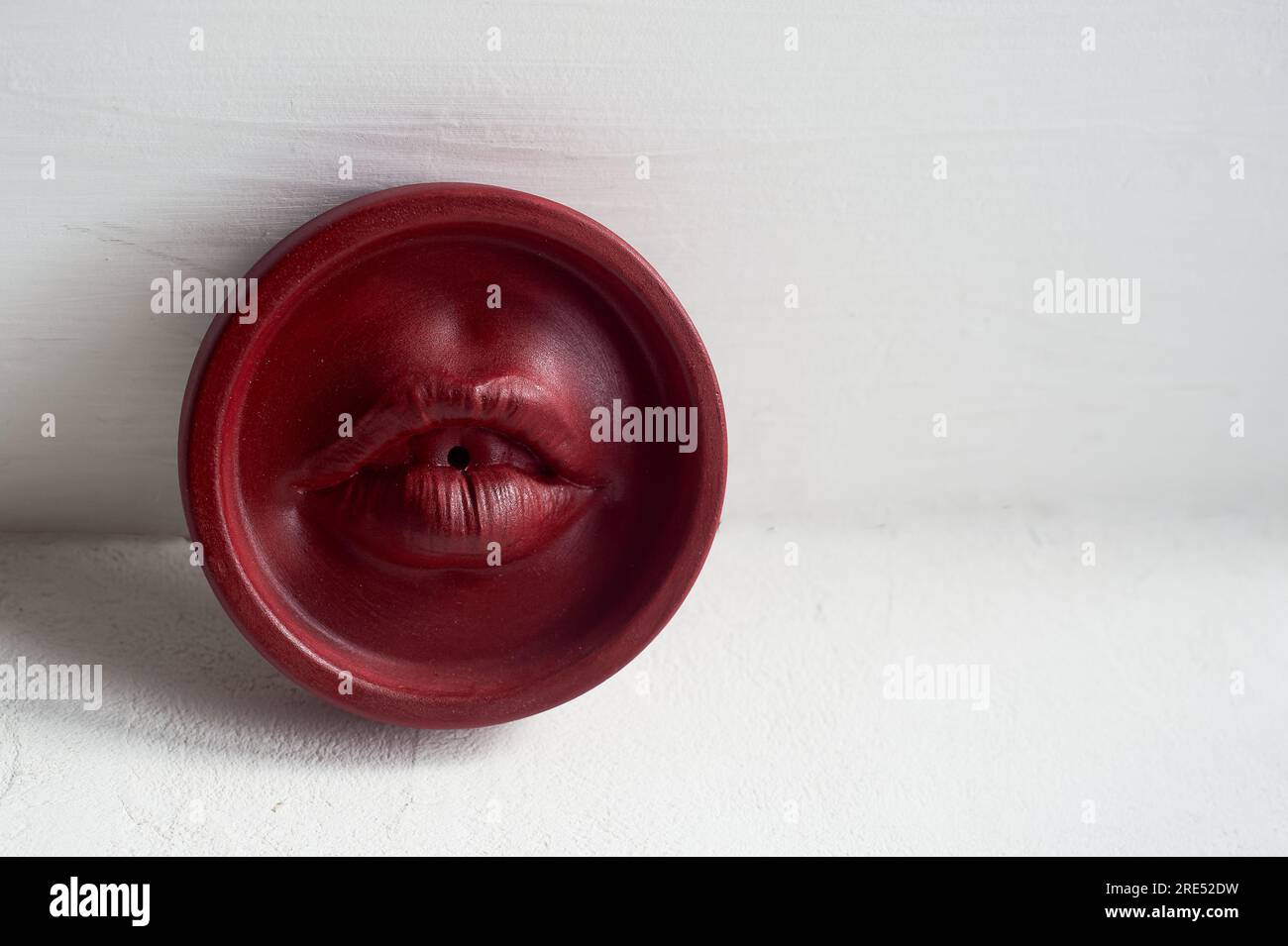 Supporto incenso labbra rosse. Forma rotonda su sfondo bianco. Esoterismo, meditazione Foto Stock