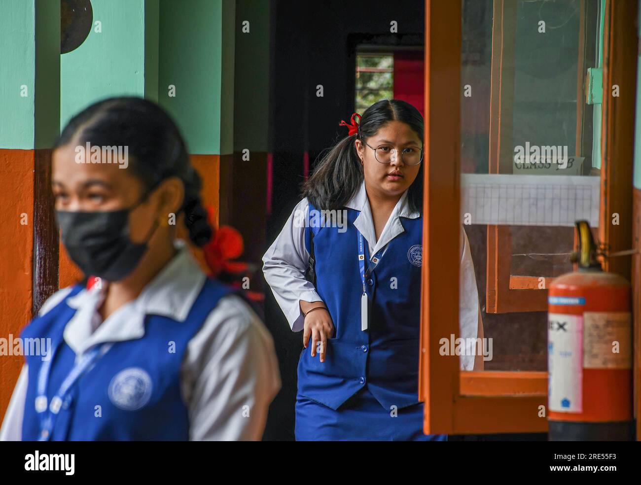 Una studentessa reagisce alla telecamera mentre entra nella sua classe alla Nirmalabas High School di Imphal. Diversi studenti hanno espresso la speranza che le scuole rimanessero aperte e desideravano la pace nello stato di Manipur, poiché lo stato ha vissuto periodi di calma a seguito della violenza etnica scoppiata per la prima volta il 3 maggio. La situazione rimane tesa, con scontri tra Meiteis, Kukis e le forze di sicurezza riportati a intervalli regolari. Uno degli impatti più gravi della prossima epidemia nello stato è stato sull'istruzione. Foto Stock