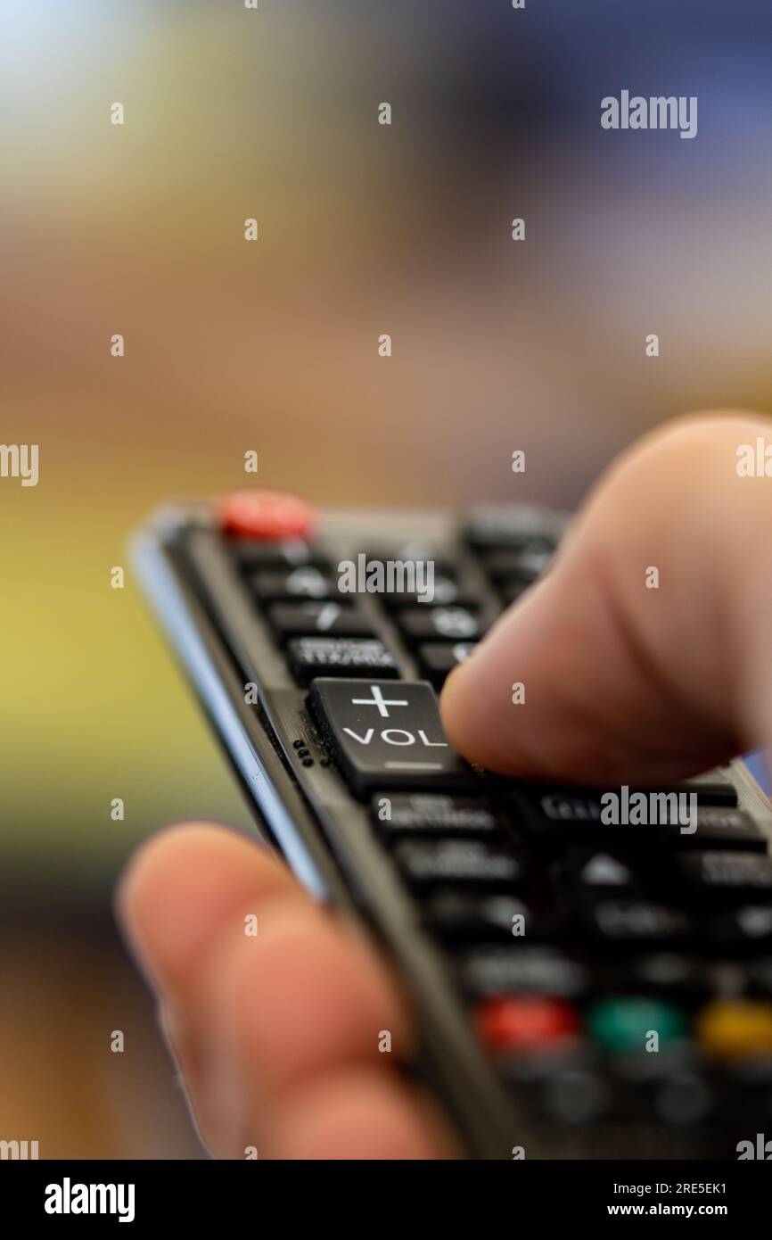 cambiare i programmi sul televisore con il telecomando. guarda i video in streaming, scegli la serie in streaming su smart tv. telecomando per passare da un film all'altro sul televisore Foto Stock