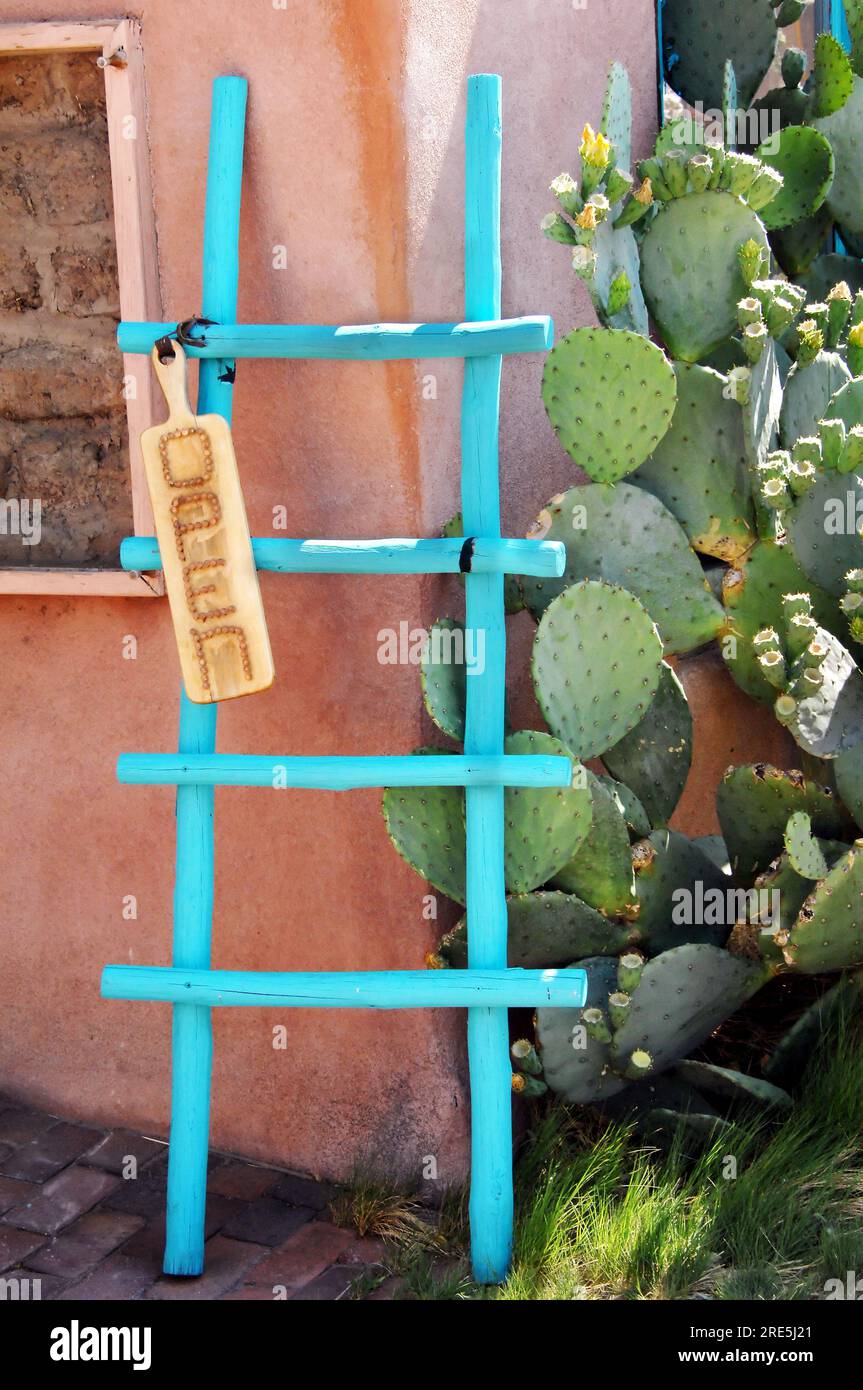 La colorata scala in legno turchese attira l'attenzione dei visitatori della "città vecchia", Albuquerque, New Mexico. Il cartello allegato dice "aperto" e il cactus è bloomin Foto Stock