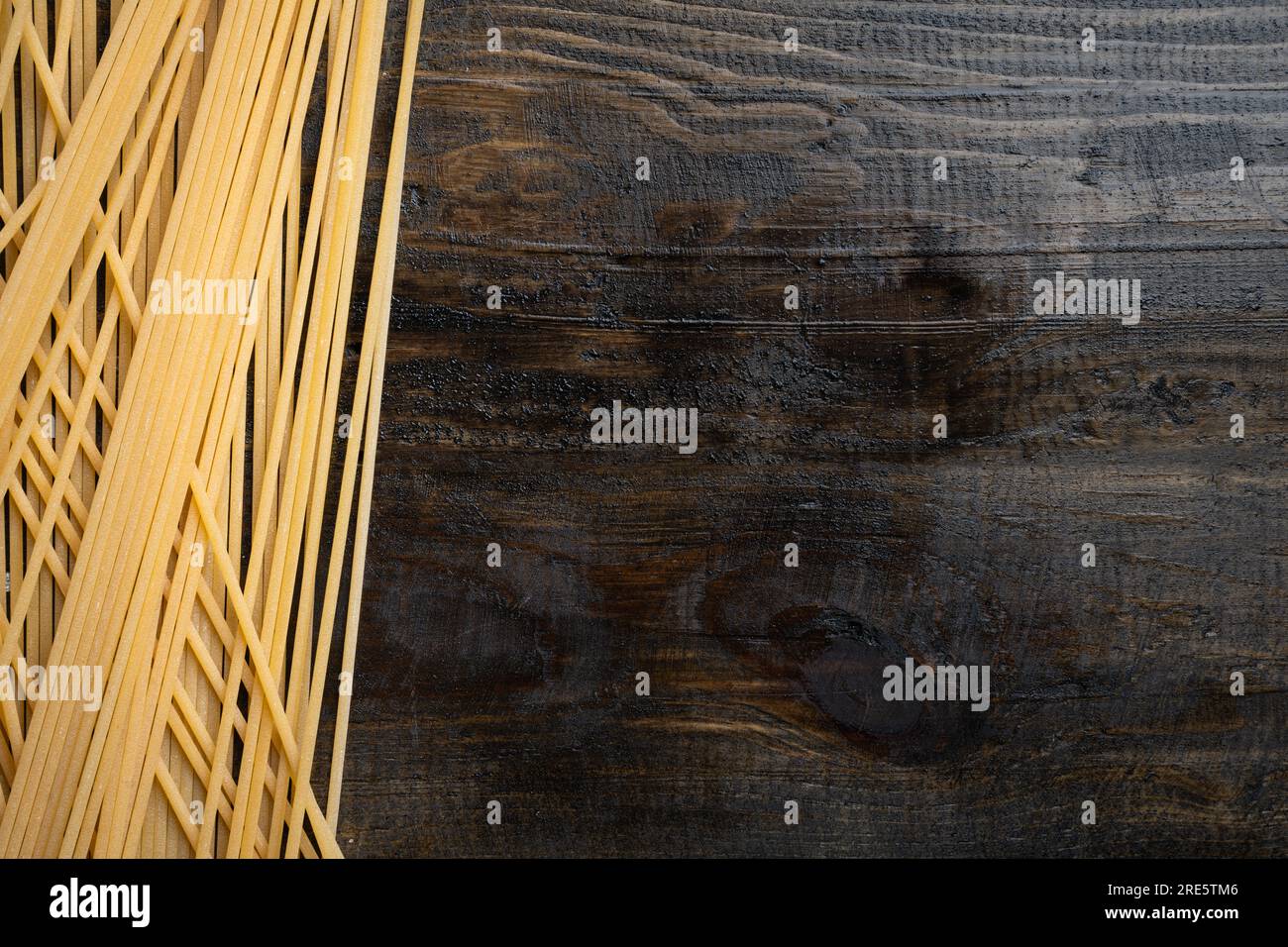 Spaghetti crudi crudi, pasta italiana su sfondo di legno, vista dall'alto Foto Stock