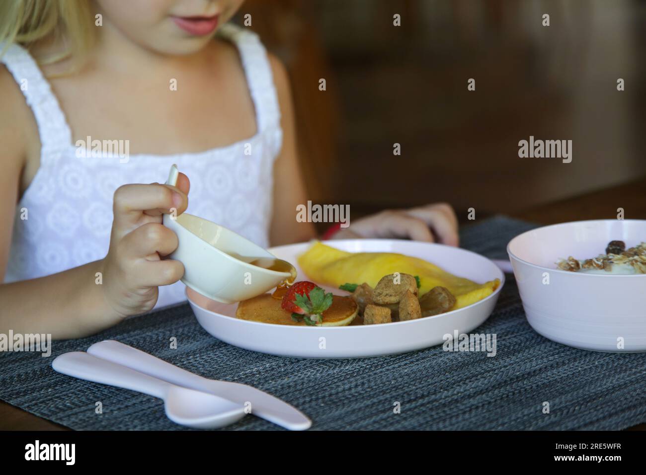 Adorabile ragazza di 5 anni che fa colazione al ristorante Foto Stock