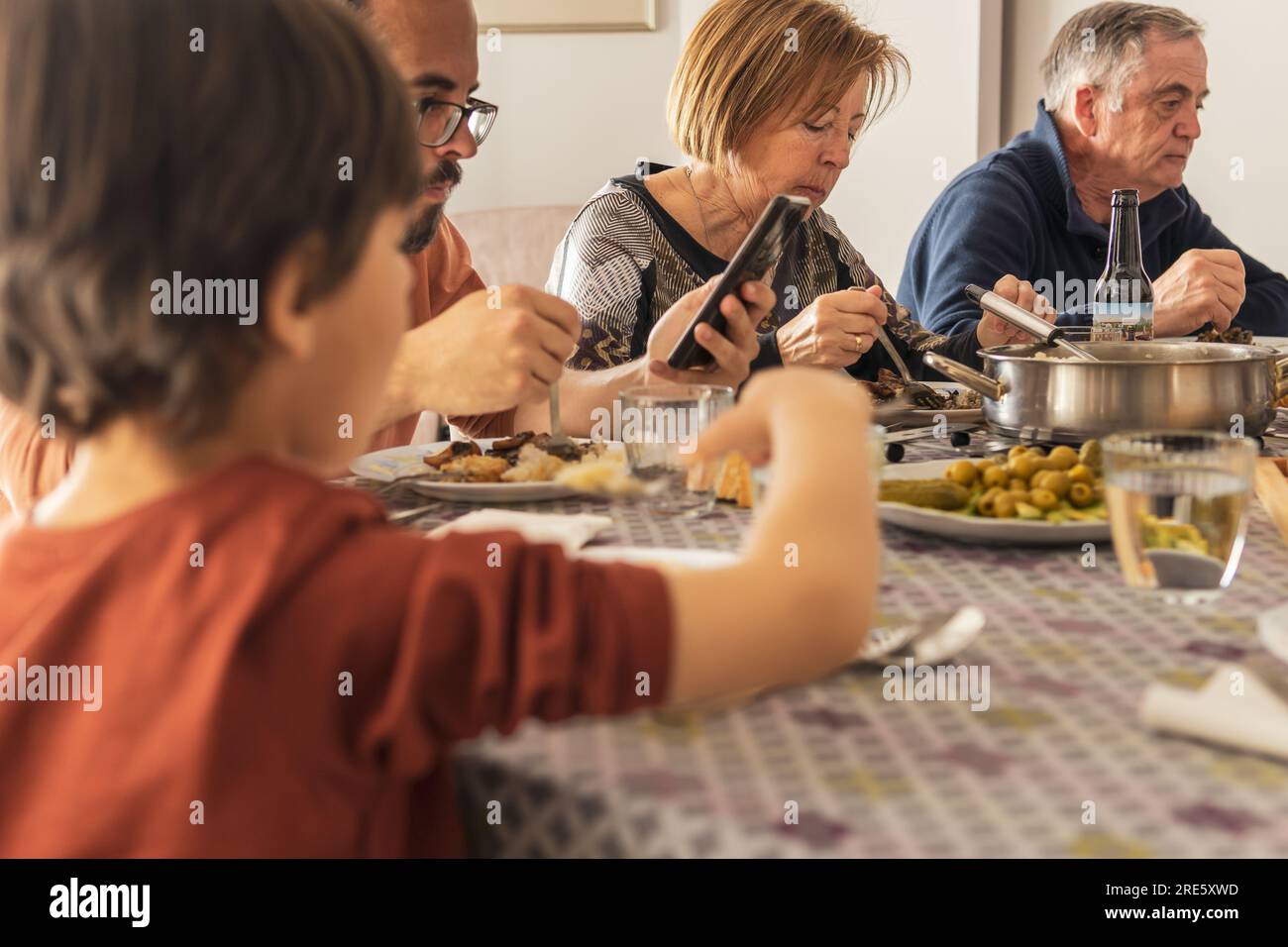 controllo del telefono cellulare durante il pranzo e mancanza di comunicazione nelle famiglie Foto Stock