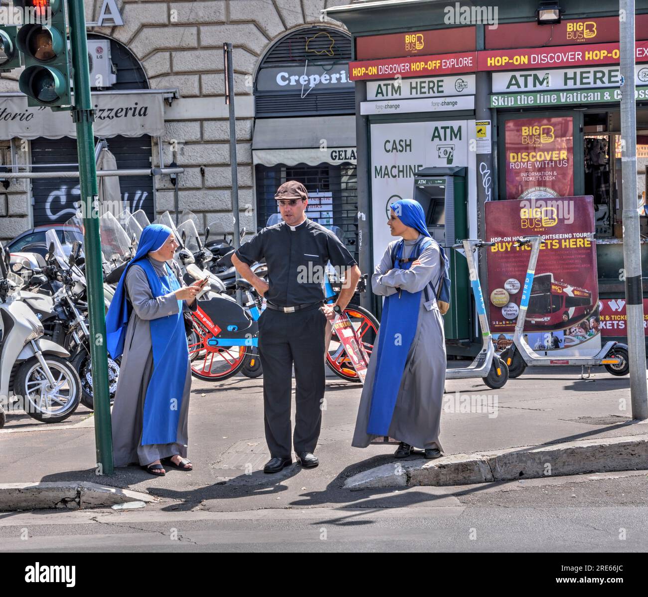 Roma, Italia - 2 settembre 2022: Un sacerdote cattolico e due suore aspettano di attraversare la strada a Roma. Editoriale. Foto Stock