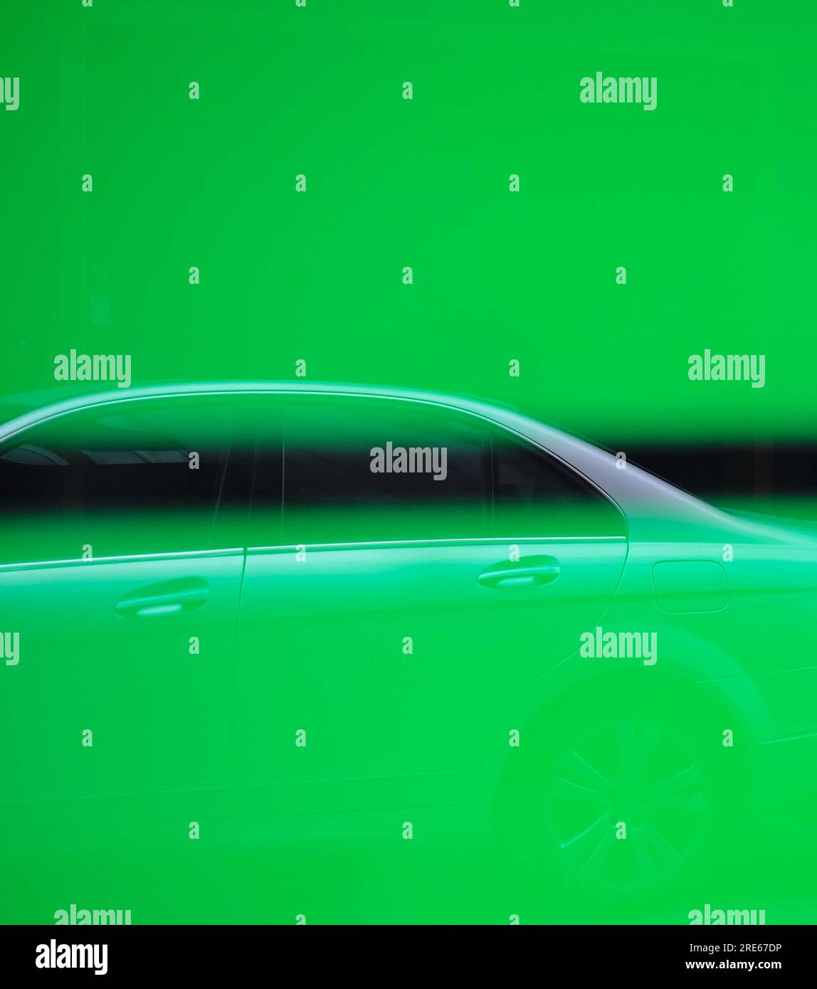 Riflesso di una moderna auto argentata su una superficie in vetro con strisce verdi al neon e immagine astratta da utilizzare come elemento grafico di design. Foto Stock