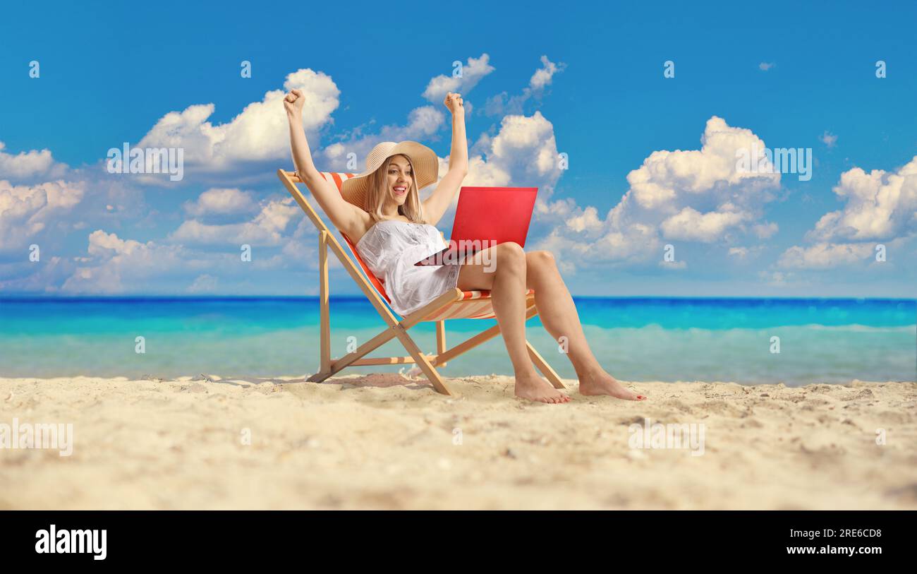 Bella giovane donna con un vestito bianco seduta sulla spiaggia