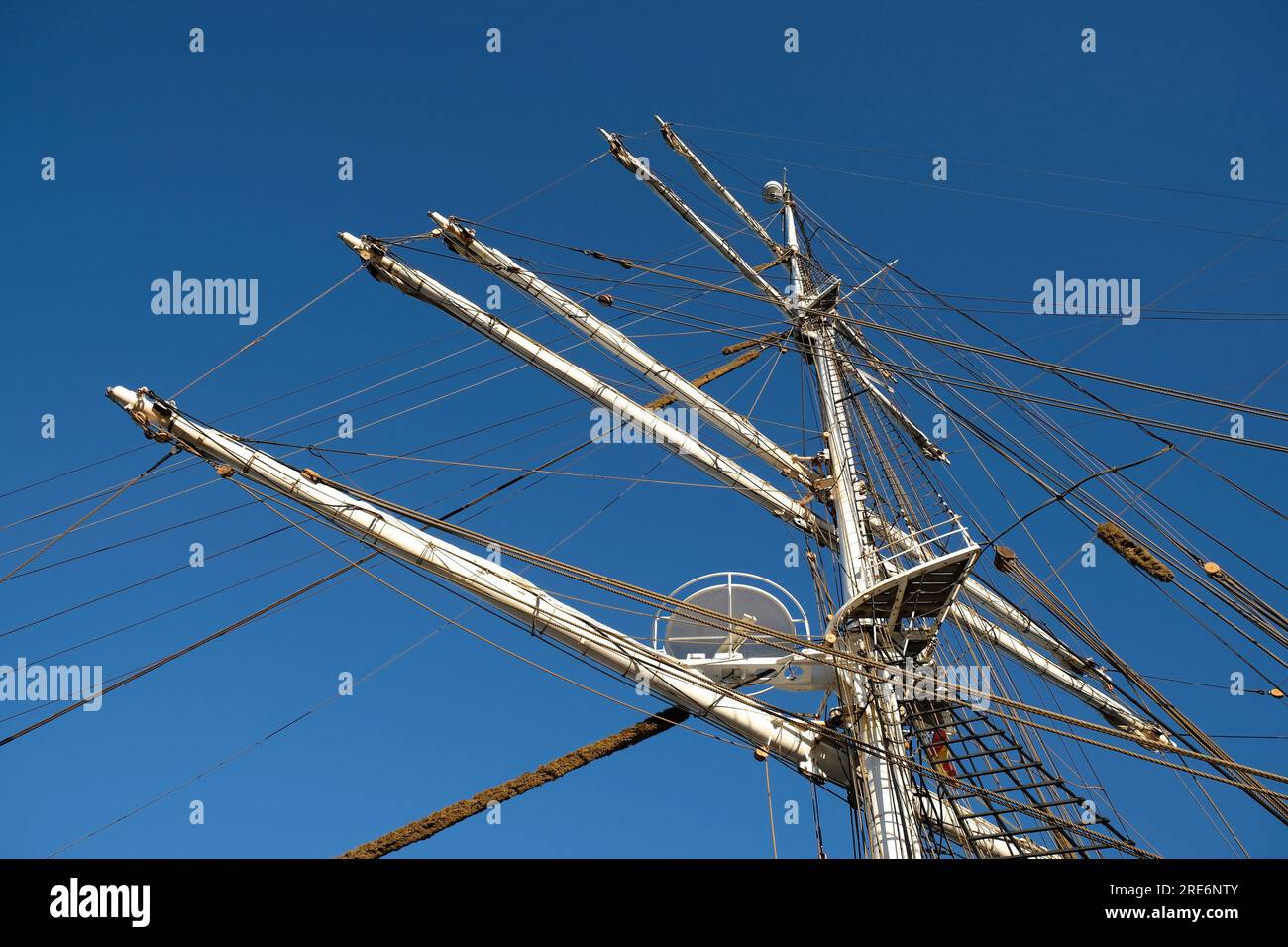 L'albero principale e i cortili di un romantico veliero classico, protezioni visibili, steli, nido d'albero e complessi sartiame, cielo blu sullo sfondo. Foto Stock