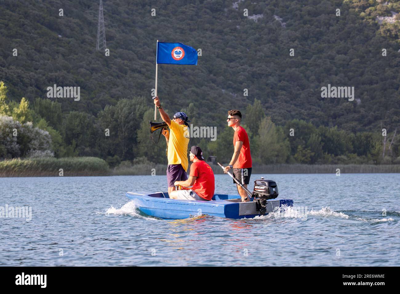 Neretva, Croazia: L'ufficiale della gara suona il corno e alza la bandiera per l'ultimo giro della gara durante una gara di canottaggio sul lago Baćina. La squadra locale "Pirates" o "Gusarice" di Baćina, Metković, Opuzen, Komin e Donjanke completò un percorso di 5 chilometri. Il team Baćina ha preso il primo posto, Metkovic è stato secondo e Komin è stato terzo. (Kim Hukari/immagine dello sport) Foto Stock