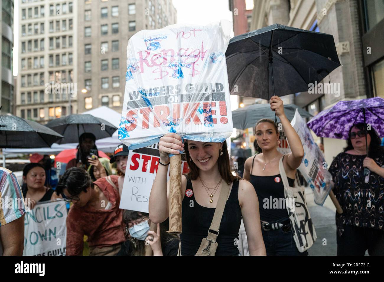I membri della Writers Guild of America picchettano davanti all'ufficio della Warner Brothers Discovery, New York il 25 luglio 2023, nonostante la forte pioggia. Foto Stock