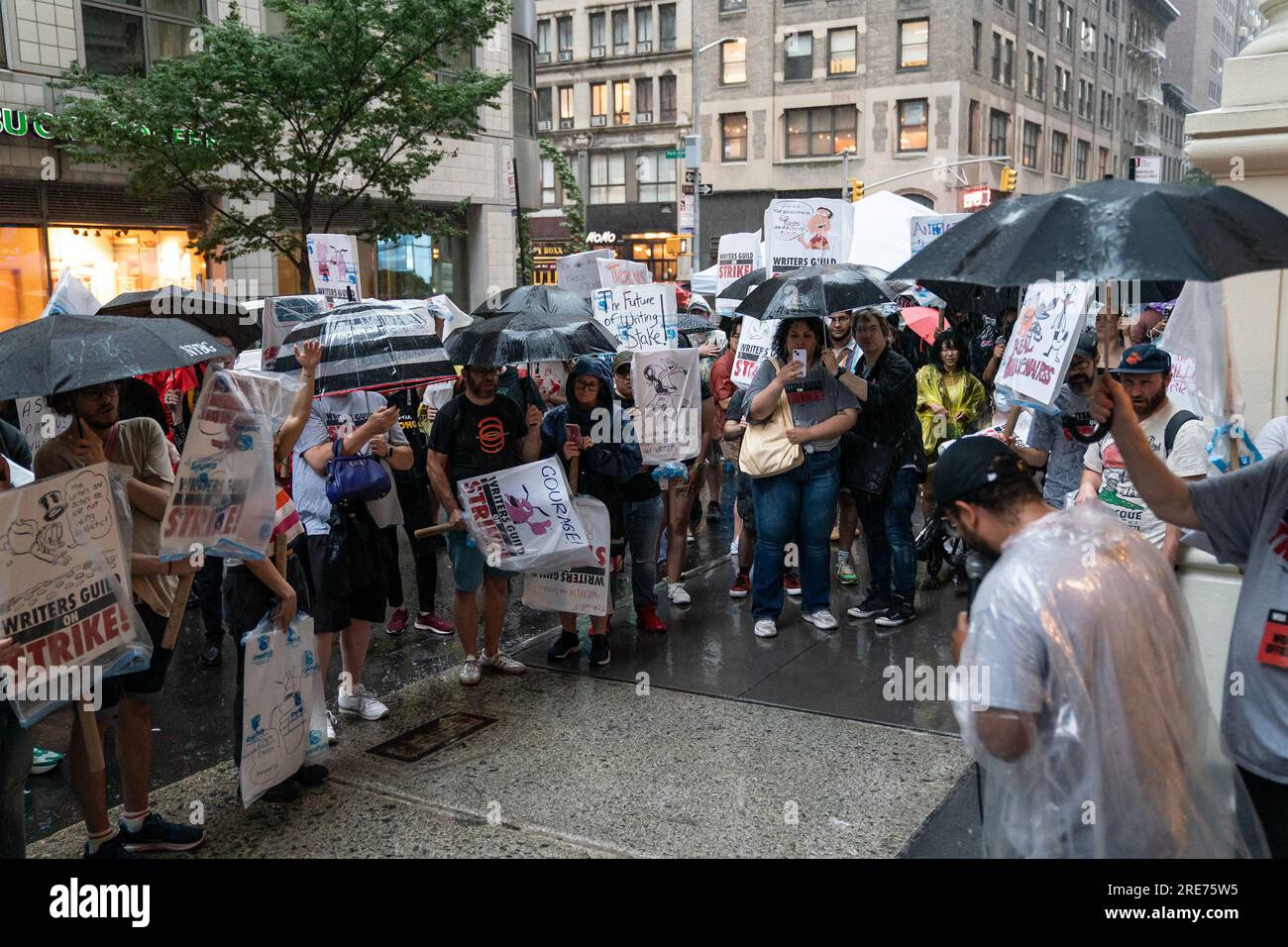New York, Stati Uniti. 25 luglio 2023. I membri della Writers Guild of America picchettano davanti all'ufficio della Warner Brothers Discovery, New York, nonostante la forte pioggia. (Foto di Lev Radin/Pacific Press) Credit: Pacific Press Media Production Corp./Alamy Live News Foto Stock