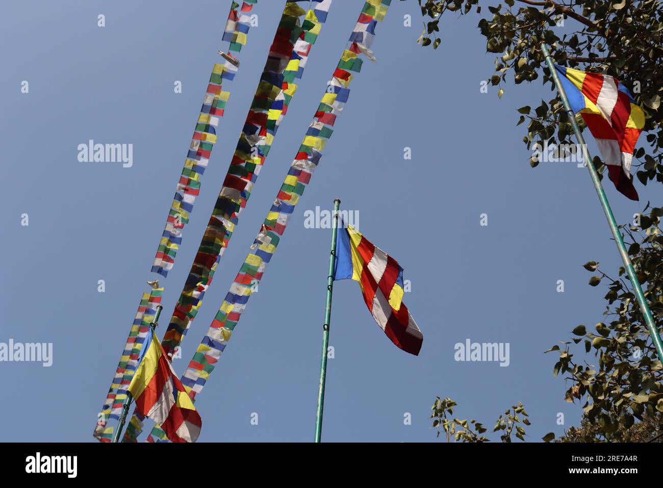 Le bandiere sono appese alla linea di corda e al palo su sfondo blu brillante del cielo, bandiere di colori diversi che sventolano nel soffice cielo blu soleggiato Foto Stock