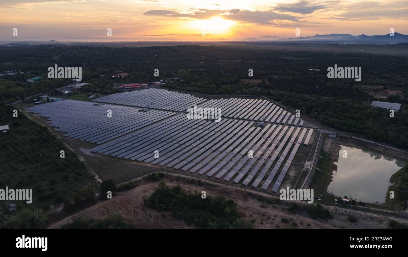 Vista aerea dei pannelli solari sullo sfondo del cielo al tramonto, concetto di energia alternativa pulita e verde. Raggi di tramonto su una centrale fotovoltaica. Foto Stock