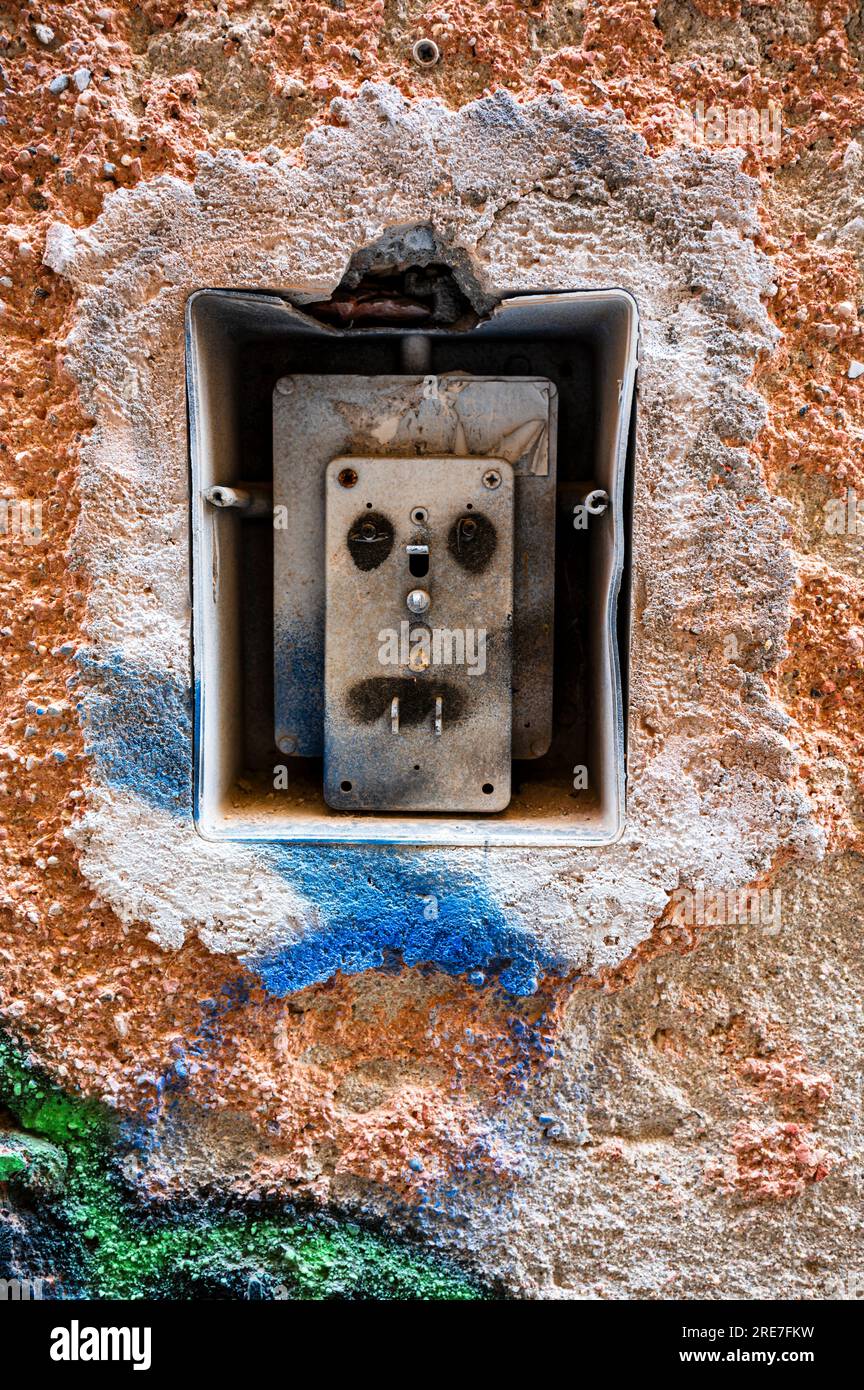Interruttore luci esterne rotto e danneggiato dalla vernice. Concetto di fotografia. Parete esterna in decomposizione. Foto Stock