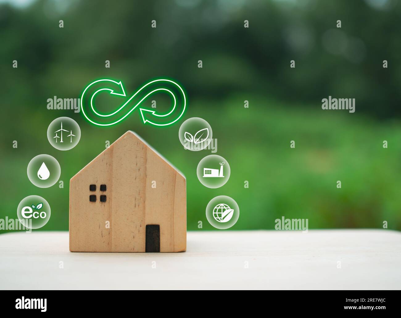 Modello di casa in legno con simbolo verde di riciclo su sfondo naturale. Concetto di riciclaggio. concetto di protezione ambientale Foto Stock