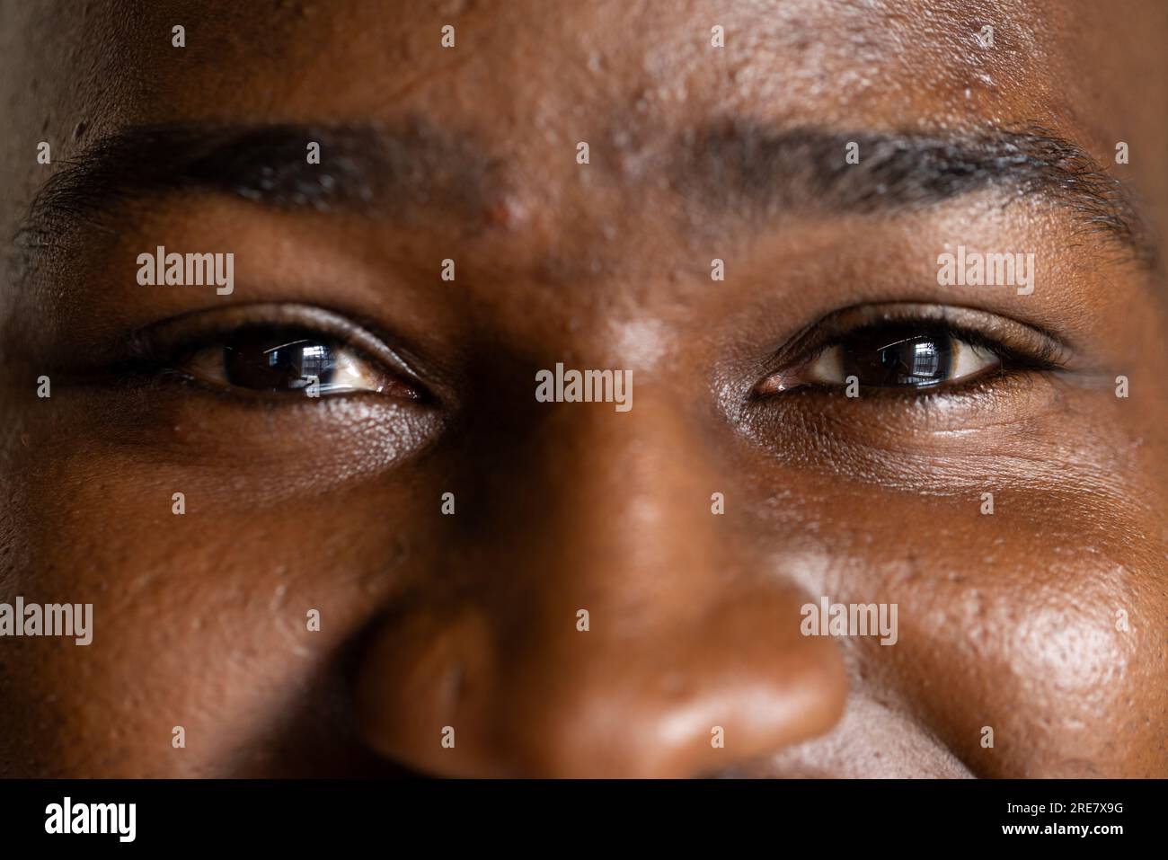 Primo piano degli occhi di un uomo d'affari afroamericano in ufficio Foto Stock