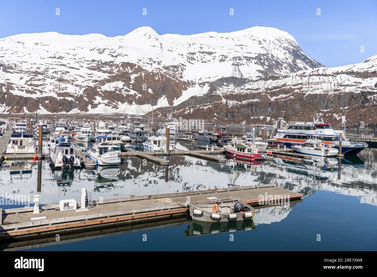 Montagna innevata che si riflette nelle calme acque del porto turistico di Whittier, Whittier, Alaska, USA Foto Stock