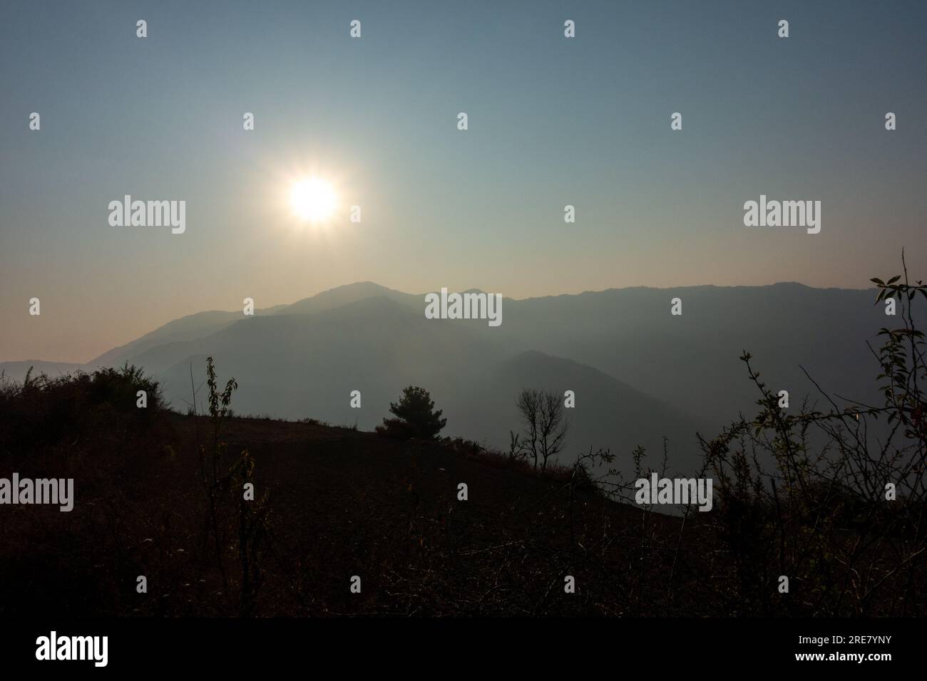 Il sole del mattino splende sul monte Naag Tibba, situato a Uttarakhand, India, creando un'atmosfera nebbiosa, creando un'atmosfera nebbiosa. Foto Stock