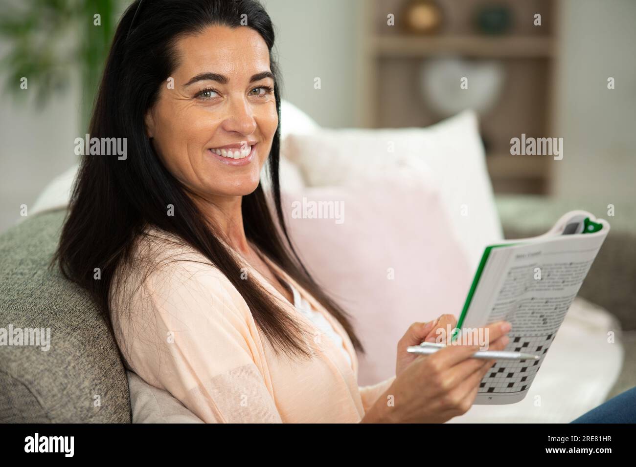 la donna sta risolvendo rompicapo di parole incrociate Foto Stock
