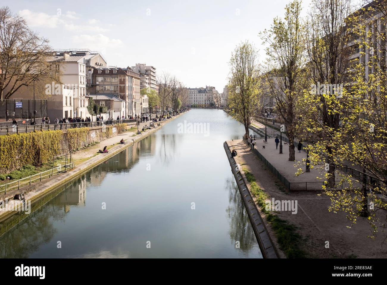 Guardando lungo il canale nell'emergente area di Canal Saint Martin di Parigi, in una splendida giornata primaverile. Foto Stock